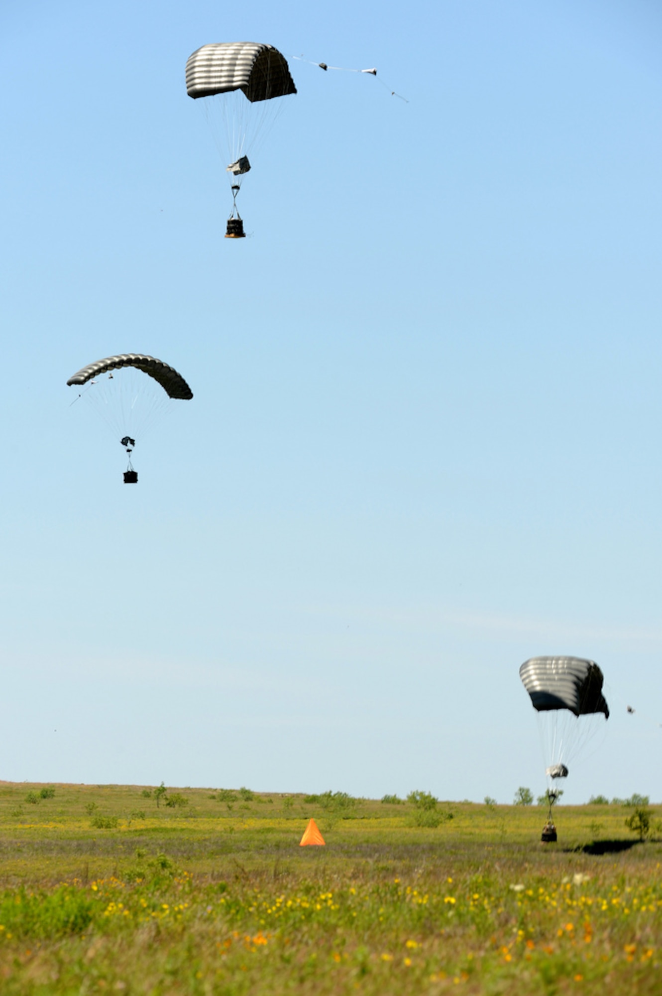 Joint Precision Airdrop System (JPADS) bundles land close to the intended target during a training exercise Tuesday, April 24, at the Antelope Drop Zone at Fort Hood. JPADS is an airdrop system that uses Global Positioning Satellite, steerable parachutes and an onboard computer to steer loads to a designated point of impact on a drop zone. (Photo by Daniel Cernero, III Corps and Fort Hood Public Affairs)