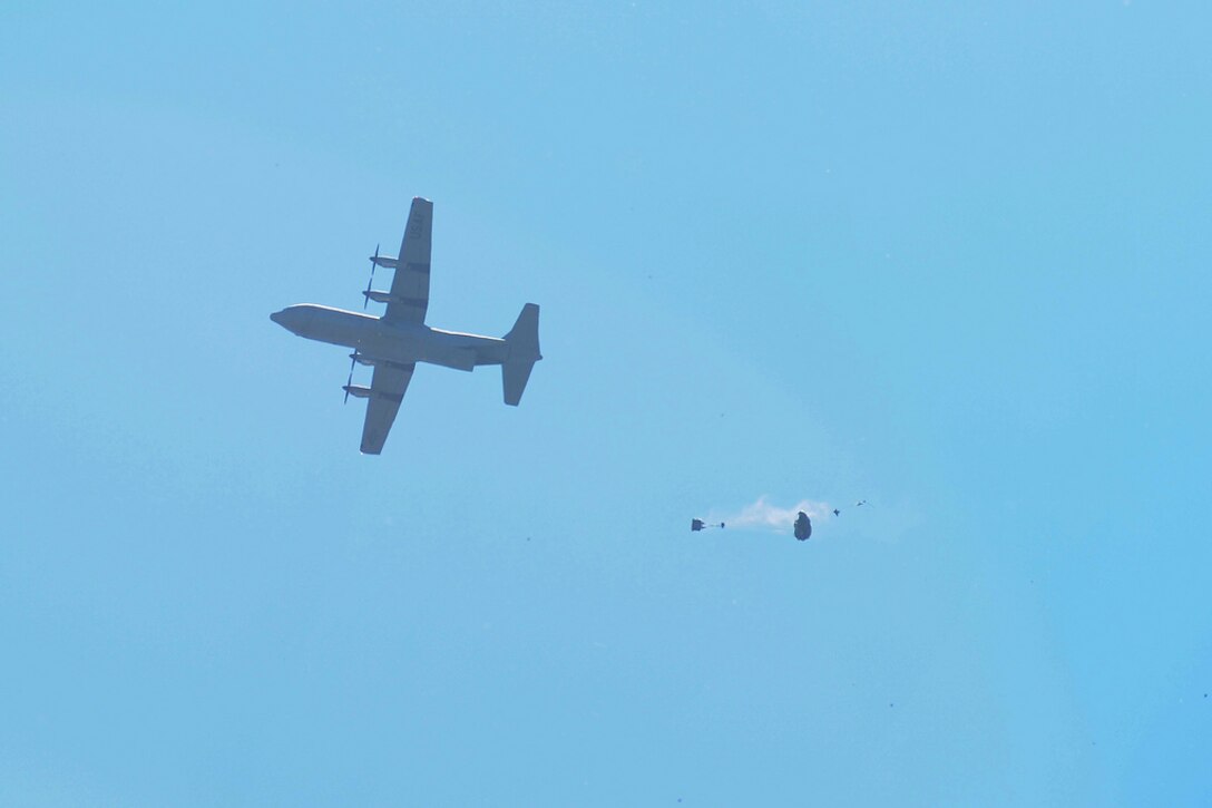 A C-130 releases a Joint Precision Airdrop System (JPADS) bundle during a training exercise Tuesday, April 24, at the Antelope Drop Zone at Fort Hood. The joint exercise was conducted by the Air Force's 317th Airlift Group, responsible for flying the C-130s, and the National Guard's 294th Quartermaster Company, responsible for packing, rigging and loading the bundles onto the aircraft. (Photo by Daniel Cernero, III Corps and Fort Hood Public Affairs)