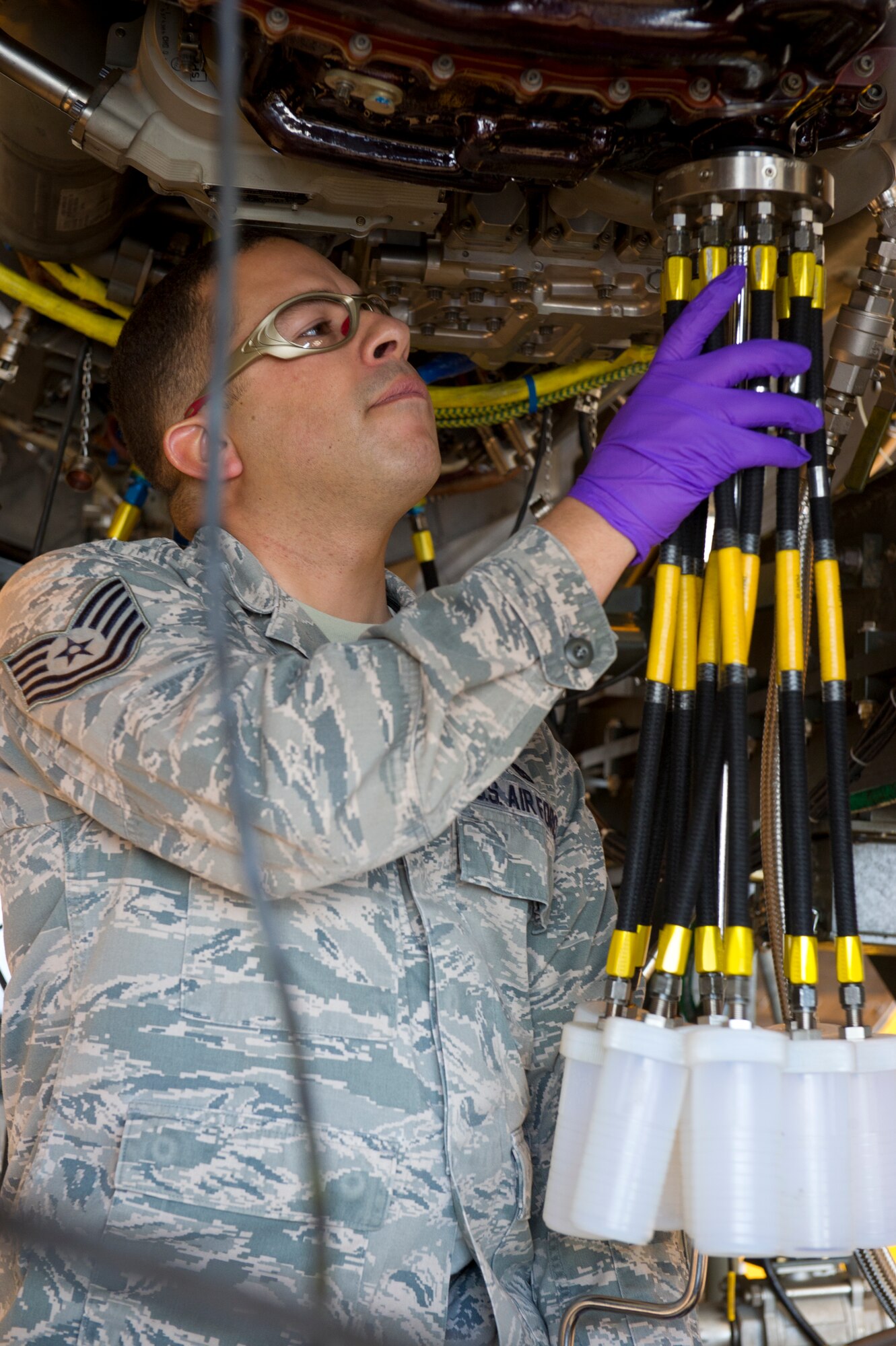 HOLLOMAN AIR FORCE BASE, N.M. – Tech. Sgt. Raul Marrero, 49th Maintenance Squadron test cell technician, attaches a gang drain collector to an F119-PW-100 jet engine April 19. The gang drain helped to monitor the amount of oil that’s released from the engine as well as help determine if there were any ferrous metals in the mixture. (U.S. Air Force photo by Airman 1st Class Michael A. Shoemaker/Released)