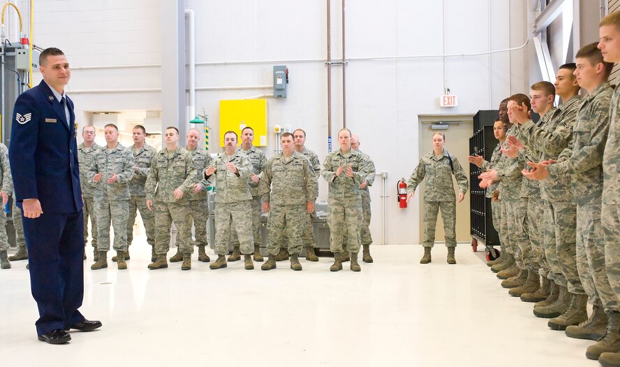 Staff Sgt. Christopher Butler, a C-5 Galaxy crew chief instructor with the 373rd Training Squadron, receives a round of applause from students and coworkers April 20, 2012, at Dover Air Force Base, Del. Butler was named the 2011 Crew Chief of the Year for the 436th Maintenance Group. (U.S. Air Force photo/Airman 1st Class Samuel Taylor)