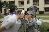 Airman 1st Class Blake Crawmer, Air Force Personnel Center, receives a pie in the face from Airman 1st Class Alissa Holub, AFPC, at the Joint Base San Antonio-Randolph Dorm Community Council's Pie-in-the-Face cookout April 20. Crawmer was randomly selected to be pied in a raffle at the event. (U.S. Air Force photo/Rich McFadden) 