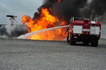 Maxwell Fire Department firefighters battle the blazing inferno during a training session on April 19. The spray is aimed at the base of the fire strategically to put out the flames as quickly as possible. (Air Force photo by Airman 1st Class William Blankenship)