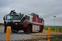 Maxwell fire fighters prepare to rush into action before simulated burning aircraft training on April 19. The trucks are parked away from the inferno at first to prepare for entering the situation in a timely manner. (Air Force photo by Airman 1st Class William Blankenship)