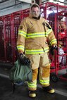 Jonalan Wright, firefighter at Maxwell Air Force Base, suits up for a training exercise on April 18. Firemen must be dressed in full gear and on the truck within 60 seconds of the alarm sounding. (Air Force photo by Airman 1st Class William Blankenship)