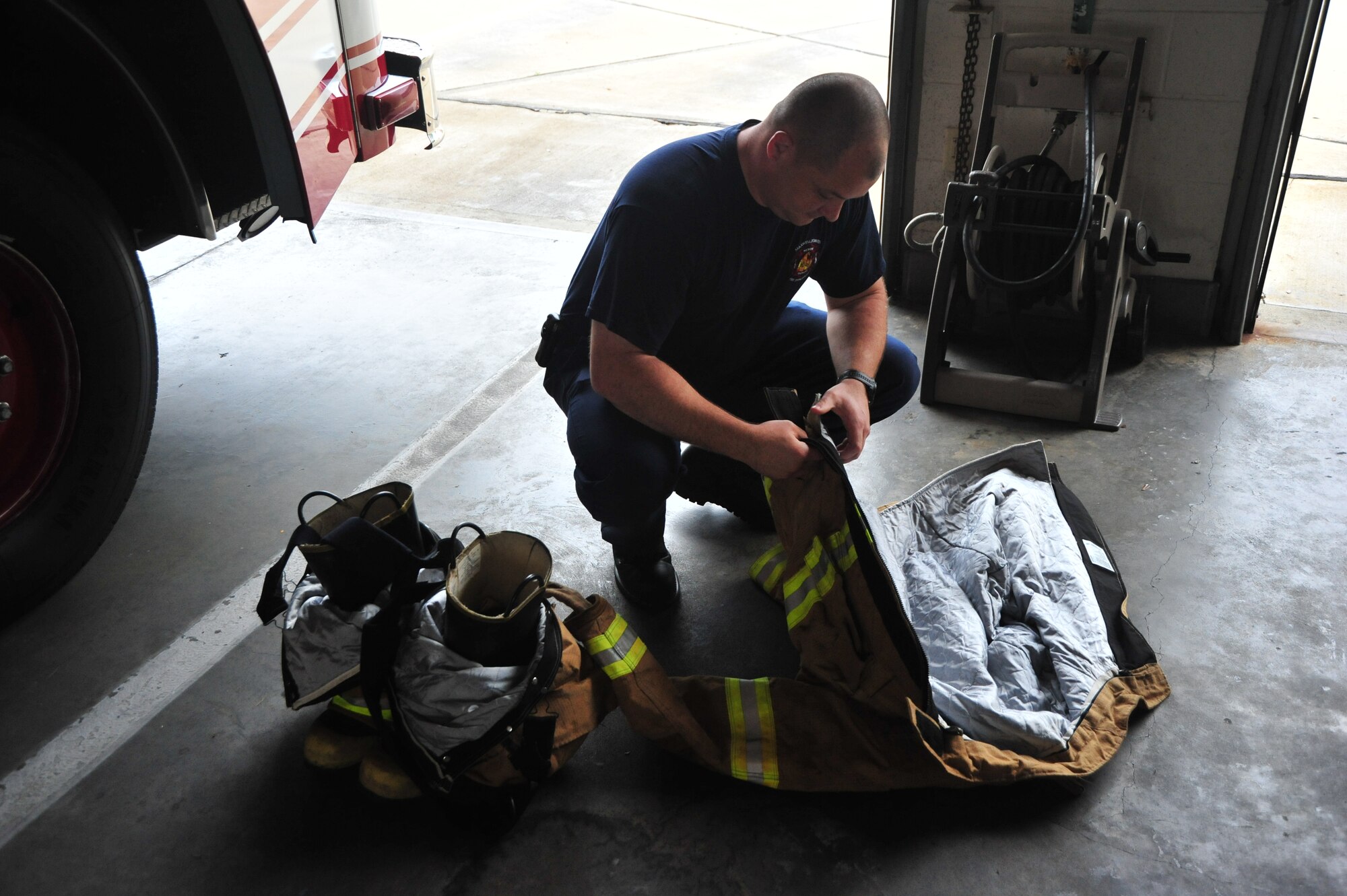 Paul Nowak, firefighter at Maxwell Air Force Base, checks his firefighter suit before a training exercise on April 19. Fire protection suits must be in working condition to be able to protect firemen in dangerous situations. (Air Force photo by Airman 1st Class William Blankenship)