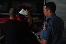 Paul Nowak and Stuart Vaughn, firefighters at Maxwell Air Force Base, check equipment prior to training on April 19. Equipment is checked daily to maintain readiness at the fire station. (Air Force photo by Airman 1st Class William Blankenship)