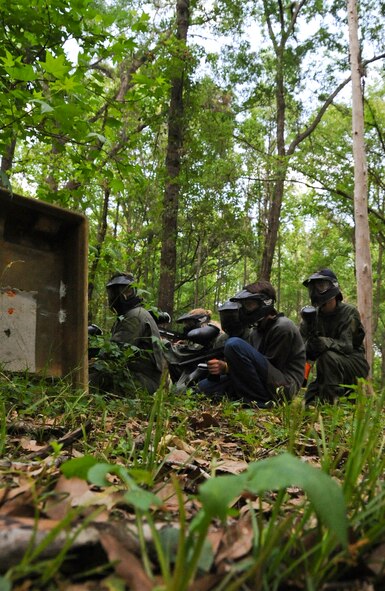 Paintball players take cover behind a barrier on Barksdale Air Force Base, La., April 15. Players are given the option to play several different game types such as elimination, president and capture the flag. Elimination is a team-based game in which each team must attempt to shoot all of the opposing team's players. President is when one team is assigned to protect an individual while the other team tries to eliminate the protected individual. Capture the flag is where each team must attempt to take the flag placed in the center of the field to the opposing team's base. (U.S. Air Force photo/Airman 1st Class Micaiah Anthony)(RELEASED)
