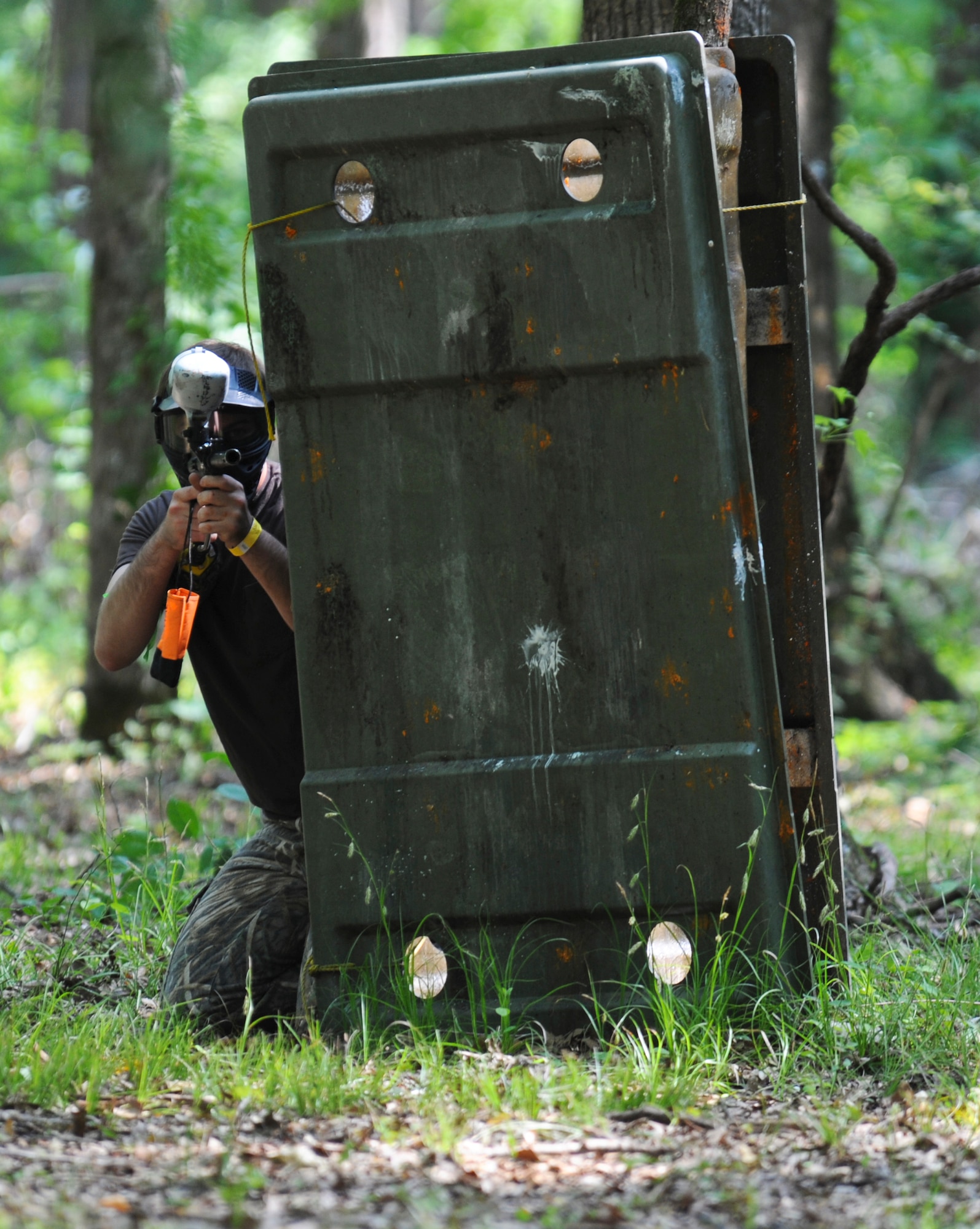 A paintball player peaks around a barrier on Barksdale Air Force Base, La., April 15. Players are given the option to play several different game types such as elimination, president and capture the flag. Elimination is a team-based game in which each team must attempt to shoot all of the opposing team's players. President is when one team is assigned to protect an individual while the other team tries to eliminate the protected individual. Capture the flag is where each team must attempt to take the flag placed in the center of the field to the opposing team's base. (U.S. Air Force photo/Airman 1st Class Micaiah Anthony)(RELEASED)
