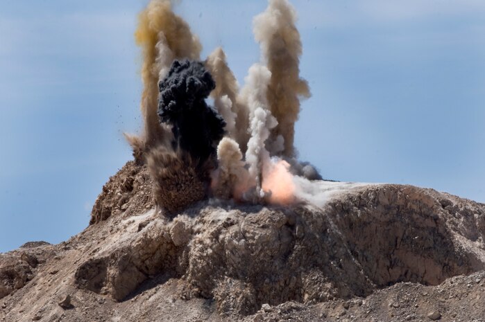 Rock is blasted off a mountain top at the 820th RED HORSE rock quarry, April 19, 2012, at Nellis Air Force Base, Nev.  Up to four hundred tons of rock can be removed with each blast.  (U.S. Air Force photo by Staff Sgt. William P. Coleman)  