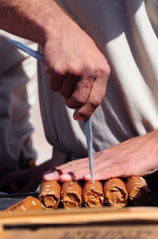 U.S. Air Force Tech. Sgt. Edison Gomez, 201st RED HORSE equipment operator, makes holes in dynamite so they can be fused together, April 19, 2012, at Nellis Air Force Base, Nev.  The dynamite will be used to blast rock away from a mountain to produce construction materials.  (U.S. Air Force photo by Staff Sgt. William P.Coleman)  