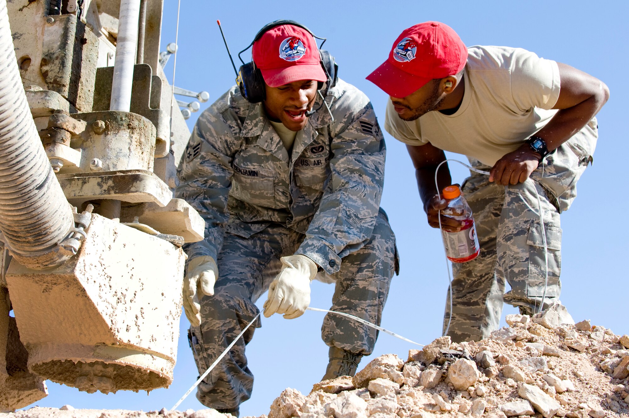 U.S. Air Force Senior Airman Tammon Benjamin, 820th RED HORSE pavement and construction journeyman, instructs Senior Airman Antoine Davis, 823rd RED HORSE equipment operator, on rock drill procedures, April 17, 2012, at  Nellis Air Force Base, Nev. The rocks drill enables the crew to make holes large enough for thirty pounds of explosives.  (U.S. Air Force photo by Staff Sgt. William P.Coleman)
  

