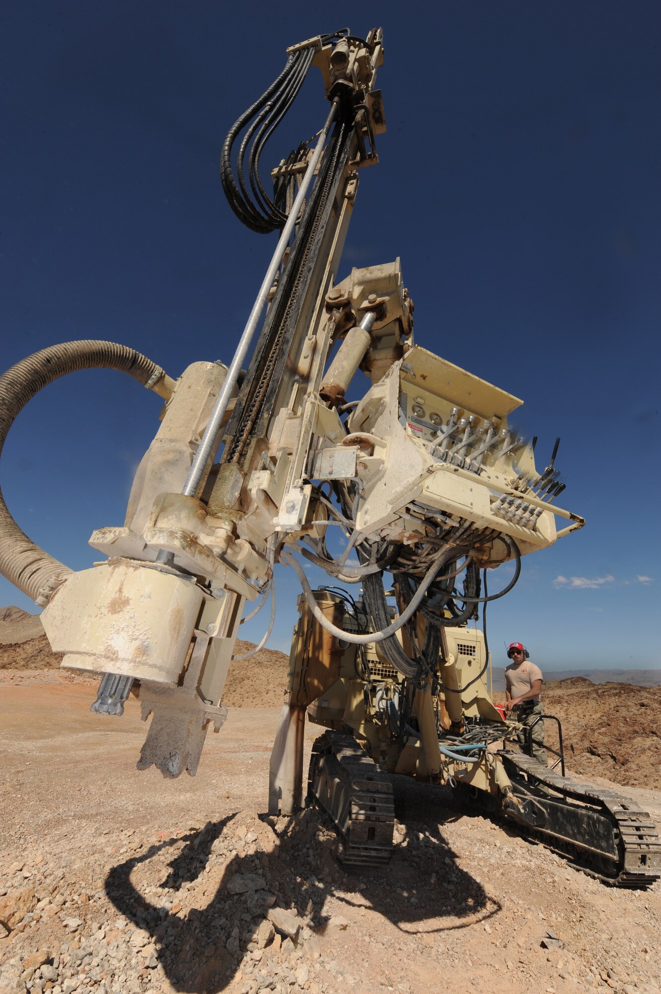 U.S. Air Force Staff Sgt. Ralph Fusaro, 201st  RED HORSE heavy equipment operator, moves the drill bit to drill a ten foot deep hole to load explosives, April 17, 2012, at  Nellis Air Force Base, Nev. A total of tens holes were drilled into the rock.  (U.S. Air Force photo by Staff Sgt. William P.Coleman)
  


