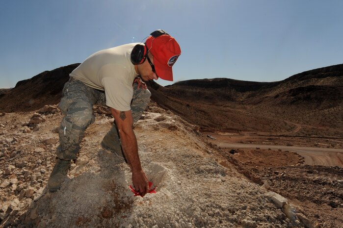 U.S. Air Force Tech. Sgt. Edison Gomez, 201st RED HORSE equipment operator, marks a hole for loading explosives, April 17, 2012, at Nellis Air Force Base, Nev. Dynamite along with ammonium nitrate will be loaded in the rock the following day.  (U.S. Air Force photo by Staff Sgt. William P.Coleman)  