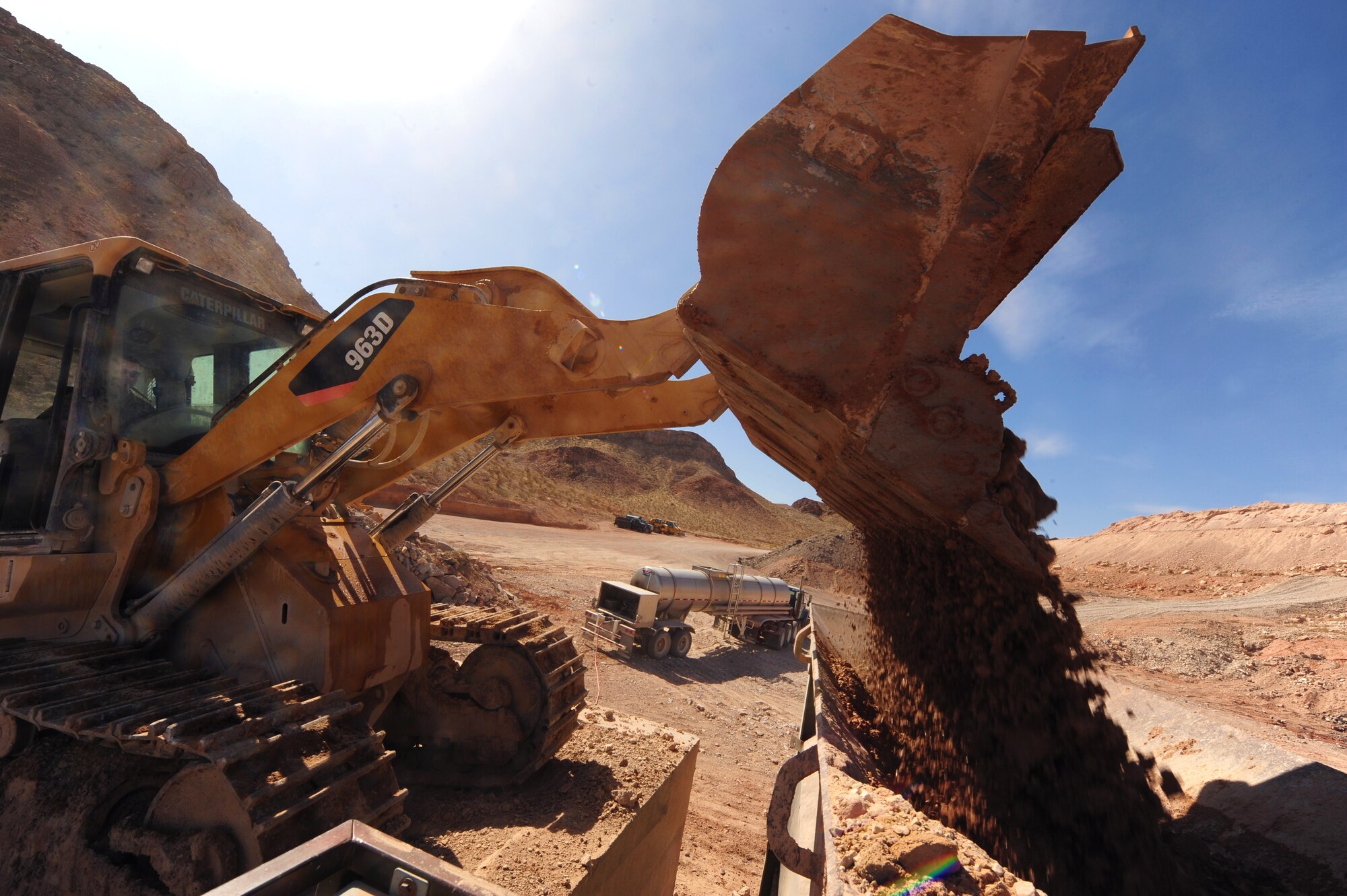 U.S. Air Force Airman 1st Class Jevin Eyman, 820th RED HORSE pavement and construction journeyman, dumps boulders into a rock crusher at the rock quarry, Mar. 27, 2012, at  Nellis Air Force Base, Nev. The rock crusher can separate the ballast and base course rocks into two piles.  (U.S. Air Force photo by Staff Sgt. William P.Coleman)
  

