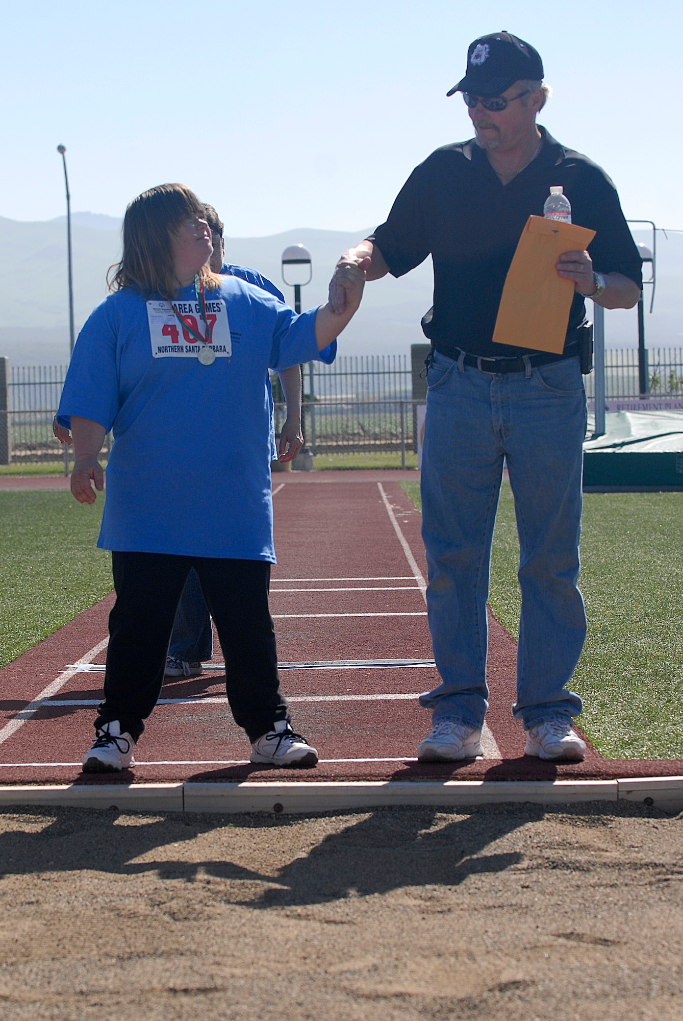 VANDENBERG AIR FORCE BASE, Calif. -- Patricia Ballew, a Special Olympics athlete, and her father Scott, prepare for the long jump during the Northern Santa Barbara County Special Olympics event at Pioneer Valley High School, Santa Maria Saturday, April 21, 2012. The Special Olympics competition is an international event that held their first summer games in Chicago, Ill. (U.S. Air Force photo/Staff Sgt. Andrew Satran) 

 
 