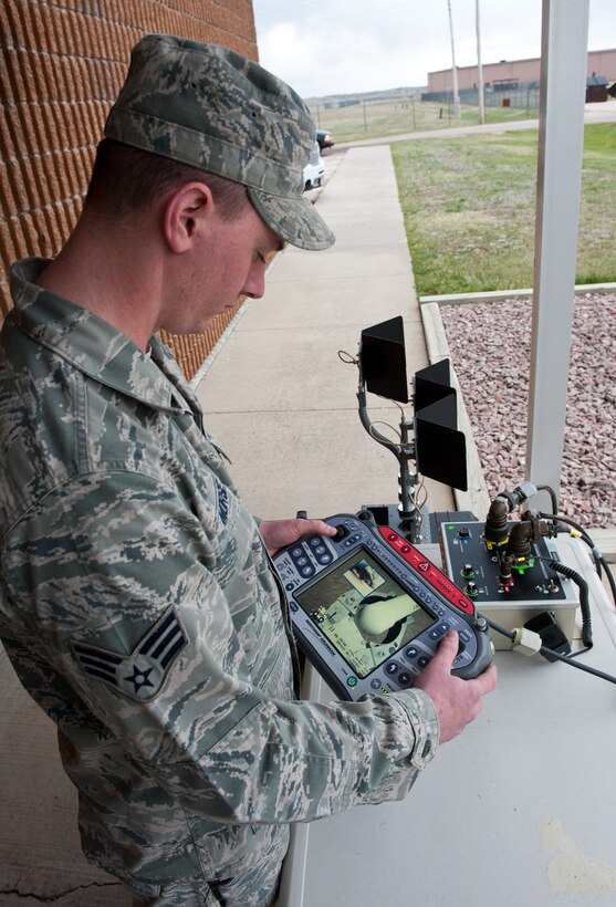 Senior Airman Luke Morse, 28th Civil Engineer Squadron explosive ordnance disposal journeyman, operates an Air Force Medium-Sized Robot during an improvised explosive device training scenario at the EOD building on Ellsworth Air Force Base, S.D., April 19, 2012. The training is designed to perfect the skills of the robot operator on the extensive features of the control box. (U.S. Air Force photo by Airman 1st Class Kate Thornton/Released)