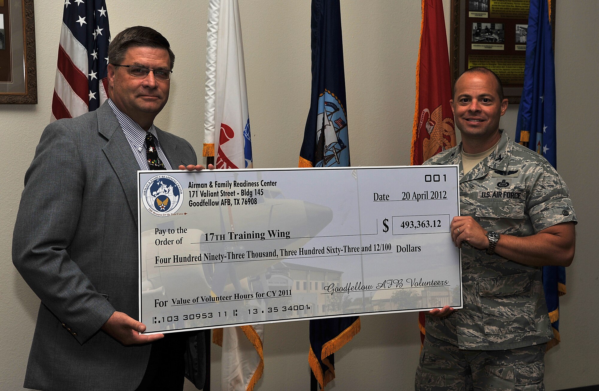 GOODFELLOW AIR FORCE BASE, Texas-- Col. Mark Damiano, 17th Training Wing Commander, and Michael Sampson, 17th Force Support Squadron Director, hold a check representing the amount of money volunteers have saved, April 20. Team Goodfellow has donated 23,685 volunteer hours from  April 2011 through March 2012. (U.S. Air Force photo/ Airman 1st Class Michael Smith)