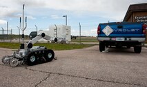 Senior Airman Luke Morse, 28th Civil Engineer Squadron explosive ordnance disposal journeyman, maneuvers an Air Force Medium-Sized Robot toward an inert training aid placed under a government vehicle during an improvised explosive device training scenario at the EOD building on Ellsworth Air Force Base, S.D., April 19, 2012. The robots provide EOD teams with a safe alternative by eliminating the need for a team member to be near the suspicious device. (U.S. Air Force photo by Airman 1st Class Kate Thornton/Released)