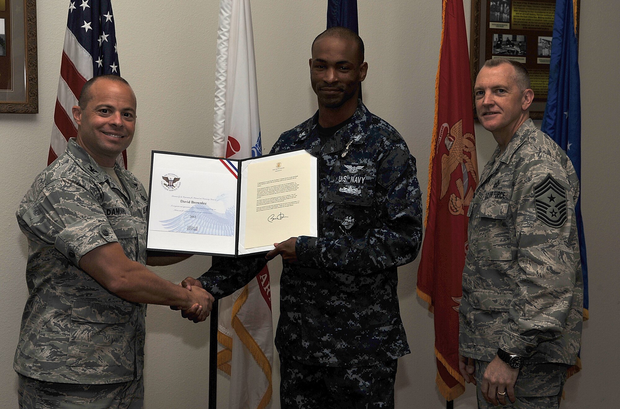 GOODFELLOW AIR FORCE BASE, Texas-- Navy Petty Officer 2nd Class David Brownlee, Center for Information Dominance Detachment, is presented the Presidential Volunteer Service Silver Level Award by Col. Mark Damiano, 17th Training Wing Commander, and Chief Master Sgt. Scott Lumpkin, 17th Training Wing Command Chief, April 20. The Silver level award is presented to adults who have accomplished 175 to 249 hours of volunteering. (U.S. Air Force photo/ Airman 1st Class Michael Smith)