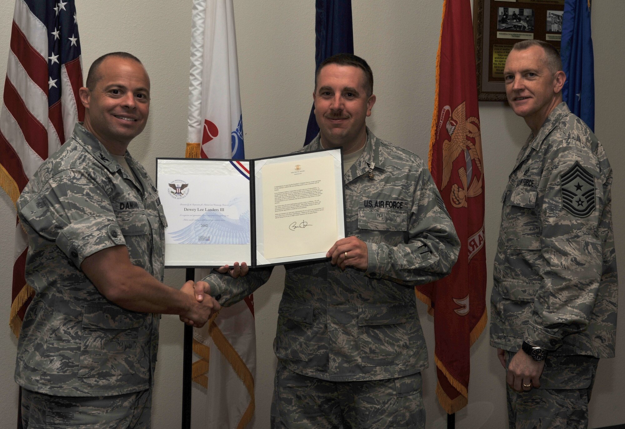 GOODFELLOW AIR FORCE BASE, Texas-- Staff Sgt. Dewey Landers, 17th Training Wing, is presented the Presidential Volunteer Service Bronze Level Award by Col. Mark Damiano, 17th Training Wing Commander, and Chief Master Sgt. Scott Lumpkin, 17th Training Wing Command Chief, April 20. The Bronze level award is presented to adults who have accomplished 100 to 174 hours of volunteering. (U.S. Air Force photo/ Airman 1st Class Michael Smith)