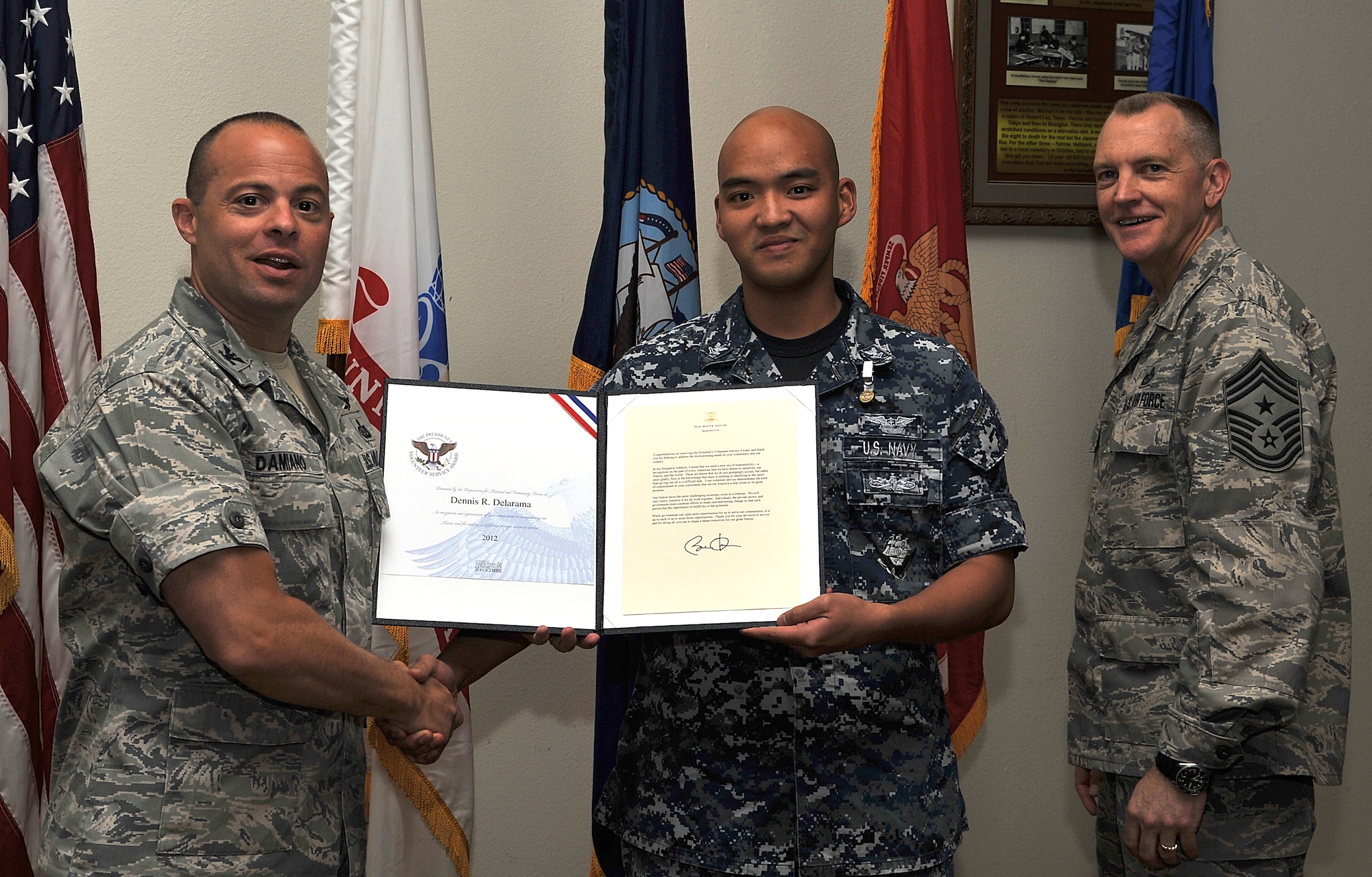 GOODFELLOW AIR FORCE BASE, Texas-- Navy Petty Officer 2nd Class Dennis Delarama, Center for Information Dominance Detachment, is presented the Presidential Volunteer Service Bronze Level Award by Col. Mark Damiano, 17th Training Wing Commander, and Chief Master Sgt. Scott Lumpkin, 17th Training Wing Command Chief, April 20. The Bronze level award is presented to adults who have accomplished 100 to 174 hours of volunteering. (U.S. Air Force photo/ Airman 1st Class Michael Smith)