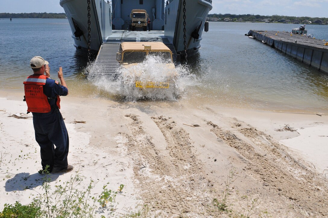U.S. Army Sgt. Bryan Rose, a watercraft operator assigned to the 97th Transportation Company, 10th Transportation Battalion, 7 Sustainment Brigade, guides a Humvee off the Landing Craft Utility 2011 ‘Chikahominy’ at Port Mayport, Fla. April 12, 2012. (U.S. Army photo by Staff Sgt. Alexander Burnett/Released)