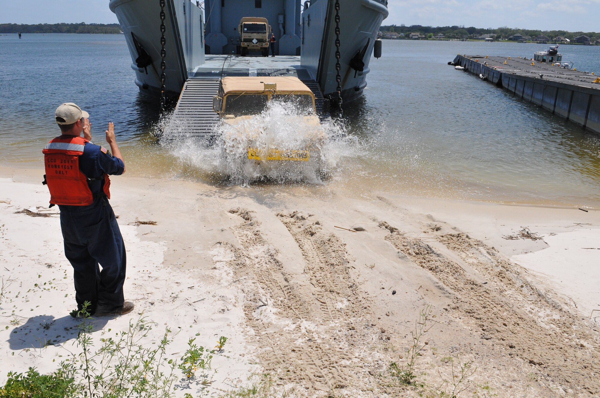 U.S. Army Sgt. Bryan Rose, a watercraft operator assigned to the 97th Transportation Company, 10th Transportation Battalion, 7 Sustainment Brigade, guides a Humvee off the Landing Craft Utility 2011 ‘Chikahominy’ at Port Mayport, Fla. April 12, 2012. (U.S. Army photo by Staff Sgt. Alexander Burnett/Released)