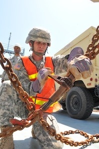 U.S. Army Spc. John Rulong, a transportation specialist assigned to the 359th Inland Cargo Transfer Company, 10th Transportation Battalion, 7th Sustainment Brigade, chains a vehicle to the deck of the Landing Craft Utility 2011 ‘Chickahominy’ while it was docked in Savannah, Ga., April 11, 2012. (U.S. Army photo by Staff Sgt. Alexander Burnett/Released)