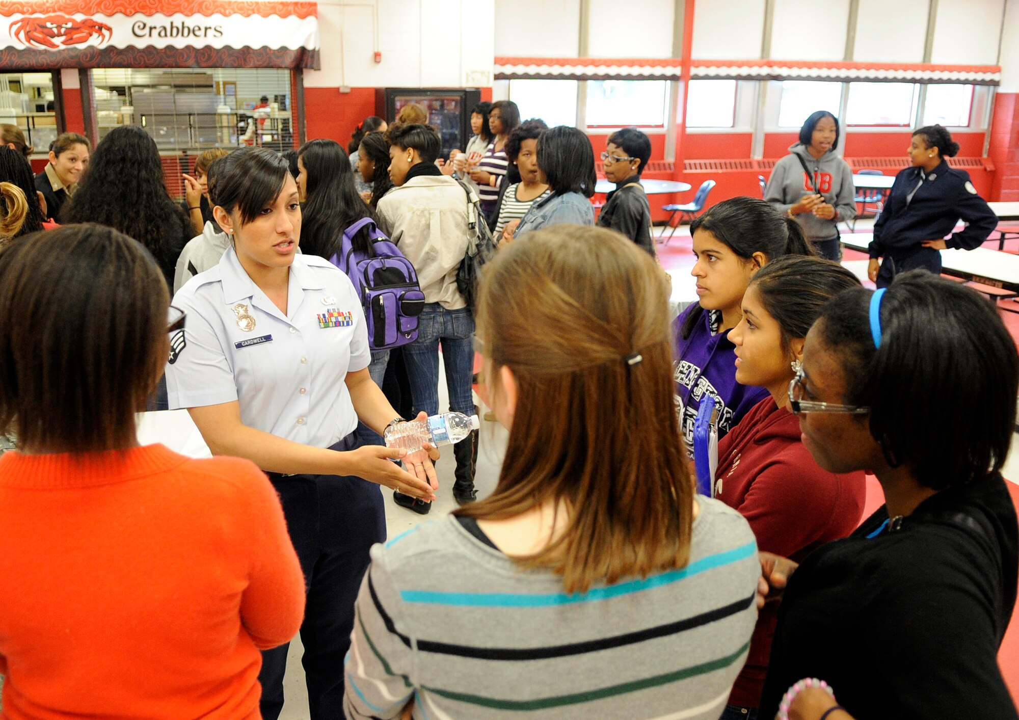 U.S. Air Force Senior Airman Stephanie Cardwell, 633d Security Forces Squadron commander's executive assistant, talks with female Air Force Junior Reserve Officer Training Corps cadets during the Women in the Military Forum at Hampton High School, Hampton, Va., April 23, 2012. The forum consisted of two portions: questions and answers, and a round-table discussion, which allowed the cadets to ask more detailed questions and receive one-on-one interaction. (U.S. Air Force photo by Staff Sgt. Dana Hill/Released)