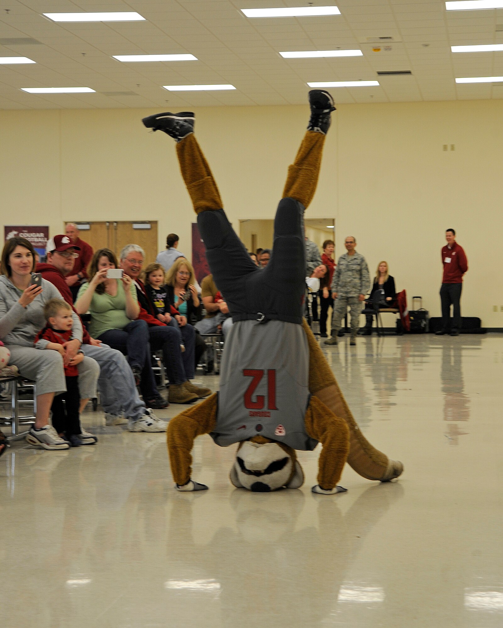 Butch T. Cougar, Washington State University’s mascot, entertains Team Fairchild and their families with a handstand in the Armed Forces Reserve Center at Fairchild Air Force Base, Wash., April 18, 2012. The primary duty of Butch is to be an ambassador of WSU. He can be seen roaming the sidelines at home football and basketball games, leading chants, and tossing shirts into the stands. (U.S. Air Force photo by Airman 1st Class Ryan Zeski/Released)