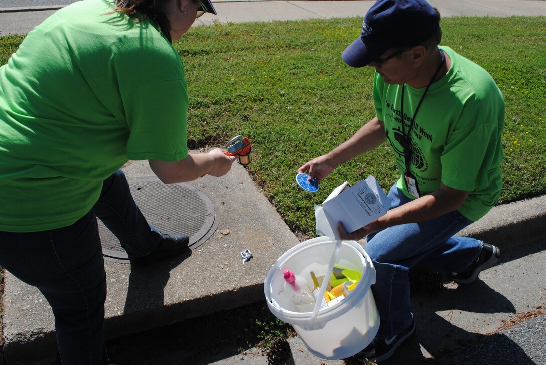 Tracy Campbell with the Army Training Support Center and Lawrence Hadsell with the 362nd Training Squadron, Detachment 1, walk Fort Eustis, Va., April 16, looking for storm drains to affix medallions that warn people to not dump in storm drains. Numerous communities celebrate Earth Week, an entire week of activities focused on environmental issues. (Courtesy photo by Toni Guagenti/Released)