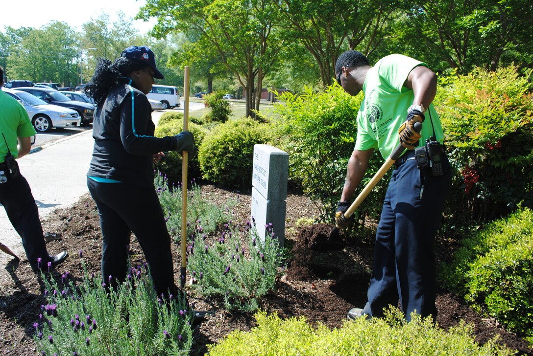 Phillip Hill, Fort Eustis firefighter, unloads mulch for a pickup and brings it over for U.S. Army Sgt. First Class Cheryl Jackson to spread in a flower bed at Fort Eustis April 16, the first day of Earth Week activities. Numerous communities celebrate Earth Week, an entire week of activities focused on environmental issues. (Courtesy photo by Toni Guagenti/Released)