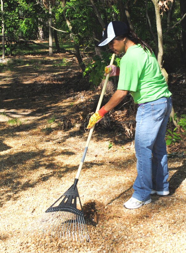Elma Ducusin, Earth Day volunteer, rakes up leaves and pine needles from the entrance of a nature trail at Fort Eustis April 16. Earth Day is an annual day on which events are held worldwide to increase awareness and appreciation of the Earth's natural environment. (Courtesy photo by Toni Guagenti/Released)