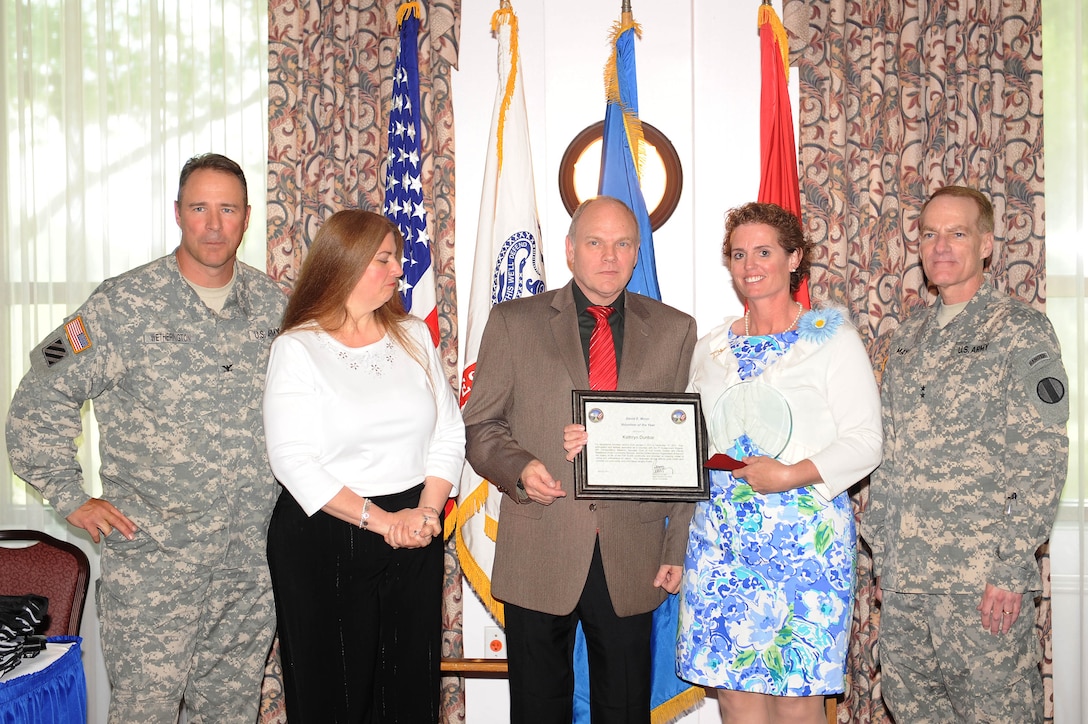 U.S. Army Col. Thomas Wetherington, 733d Mission Support Group commander, and Maj. Gen. Bradley May, commanding general Initial Military Training, present Kathryn Dunbar the David E. Minor Volunteer of the Year Award during the Fort Eustis Volunteer Recognition and Awards Ceremony at Fort Eustis, Va., April 20, 2012. The Fort Eustis Volunteer of the Year Award was named in honor of the volunteer legacy of retired Command Sgt. Maj. David E. Minor, who after 30 years of military service devoted his time to volunteer in his military community. (U.S. Air Force photo by Staff Sgt. Antoinette Gibson/Released)