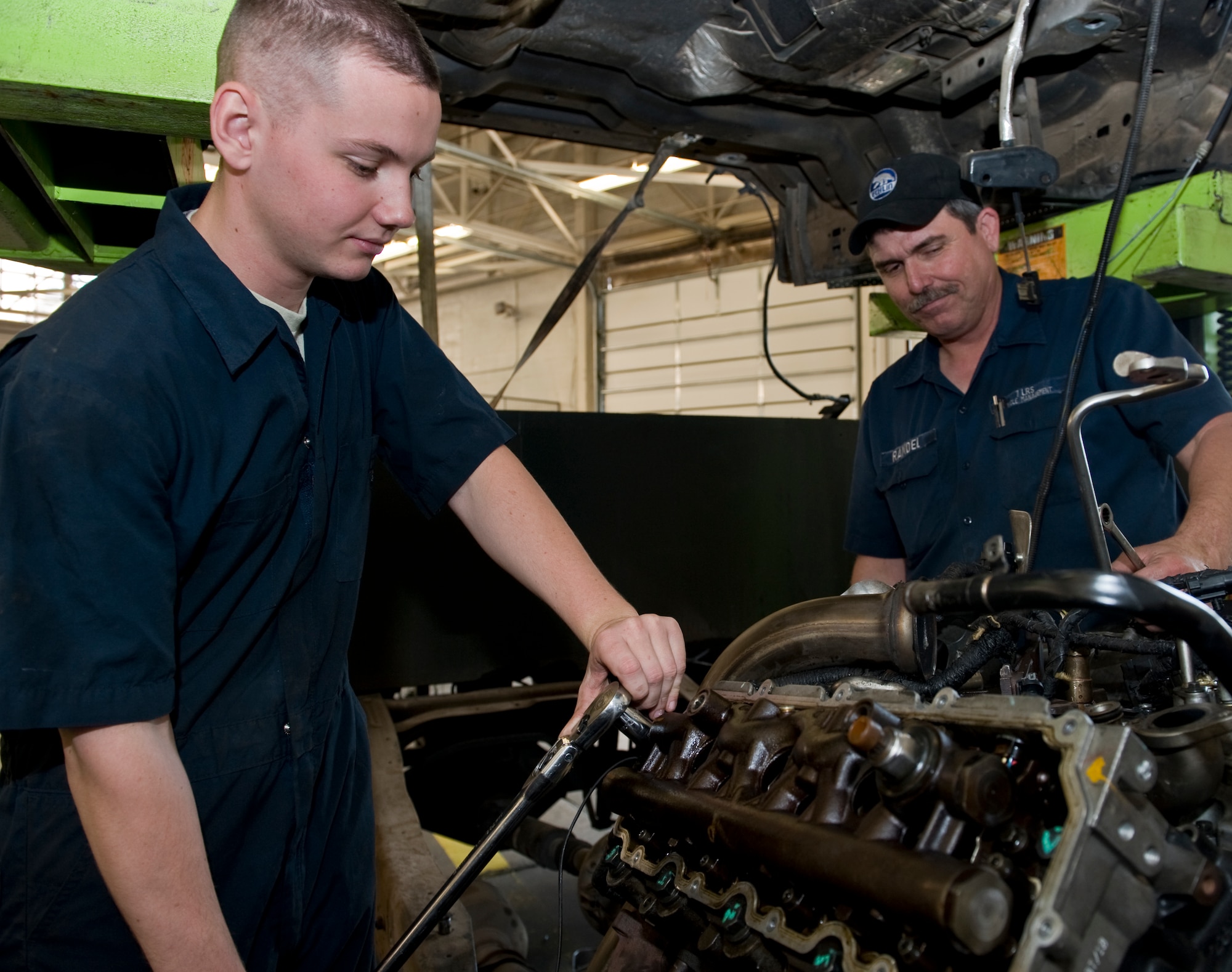 Airman 1st Class Andrew Ludwig, left, and Randel West, right, 7th Logistics Readiness Squadron, repair a Ford 6.0 diesel engine April 19, 2012, at Dyess Air Force Base, Texas. West and Ludwig created a solution to conduct in-house, cab-off engine repairs on Ford Power Stroke engines, saving the Air Force $5,000 per vehicle repair and tightening quality control measures. (U.S. Air Force photo by Airman 1st Class Jonathan Stefanko/ Released)