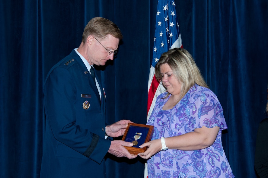 Tech. Sgt. Steven Hollon is recognized by Air Force personnel with the posthumous presentation of the Airman's Medal to his wife, Karen, daughters, Faith and Renae, and his mother, Sara. Hollon was killed while protecting his youngest daughter during a catastrophic tornado outbreak April 15, 2011. (U.S. Air Force photo by Melanie Rodgers Cox)