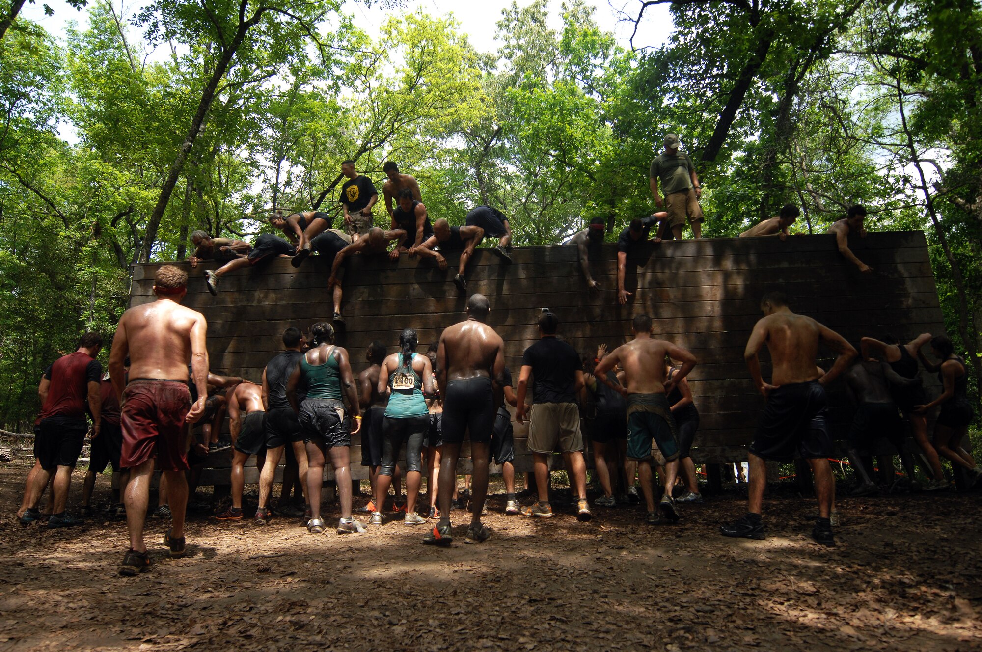 U.S. Air Force Airmen from the 20th Comptroller Squadron climb a wall at the U.S. Marine Corps 2012 Mud Run, Columbia, S.C., April 21, 2012. Airmen from the 20th CPTS split into three teams: Thunder Thunder, Thunder Cats, The Number 2's and The Mudder Funkers to participate in the Mud Run.(U.S. Air Force photo by Airman Nicole Sikorski/Released)