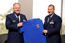 Brig. Gen. Roger W. Teague, Space and Missile Systems Center vice commander. is presented a squadron shirt by Lt. Col. Scott Trinrud, 4th Space Operations Squadron commander April 20 here. Teague, a former 4 SOPS member served as the guest speaker for the ceremony marking the squadron's 20th Anniversary. (U.S. Air Force Photo/Dennis Rogers)