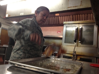 Master Sgt. Norma Gonthier prepares bacon at the Crisis Ministries kitchen in downtown Charleston. A team of volunteers from the 1st Combat Camera Squadron, Joint Base Charleston - Air Base, purchased, cooked and served breakfast to more than 120 local homeless shelter residents, including 40 veterans, April 5. Crisis Ministries, a non-profit agency in Charleston, S.C. serves almost 200,000 meals each year. Gontheir is the 1st CTCS noncommissioned officer in charge of unit training. (U.S. Air Force photo/Senior Airman Nicholas Pilch)