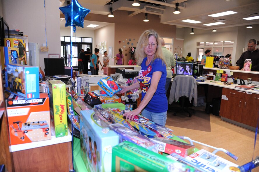 Beni Minner, Youth Center clerk, sets up the prize give-away table for the Youth Center?s ?Month of the Military Child and Child Abuse Prevention Carnival? April 21, 2012, at Dover Air Force Base, Del.  Prizes were given out randomly throughout the carnival.  (U.S. Air Force photo by Staff Sgt. Chad Padgett)
