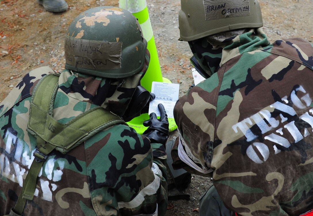 U.S. Air Force Lt. Col. Brian Ortman, right, 1st Fighter Wing Public Health commander, and Maj. Greg Garrison, left, 633rd Aerospace Medicine Squadron Bio-Environmental Engineering Flight commander, references a quick guide during a Post-Attack Reconnaissance sweep during a Phase II Operational Readiness Exercise at Langley Air Force Base, Va., April 20, 2012.  The Phase II ORE is designed to simulate a deployed environment and test self-aid and buddy care and post-attack reconnaissance response. (U.S. Air Force photo by Airman 1st Class Kayla Newman/Released)