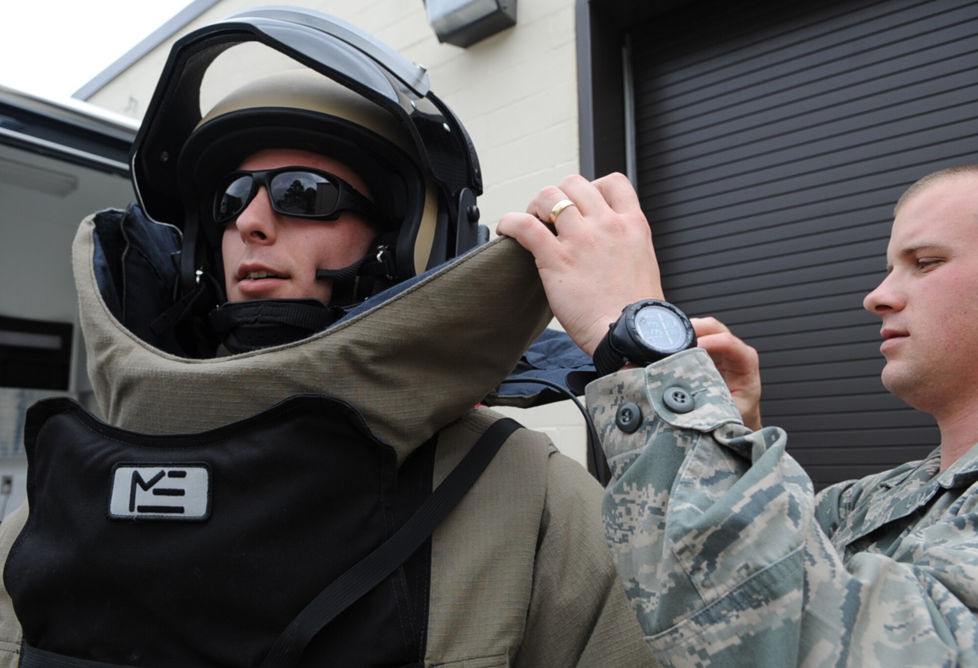 U.S. Air Force Airman 1st Class Graham Speight assists Staff Sgt. Adam Usher in donning an explosive ordnance disposal 9-bomb suit on Seymour Johnson Air Force Base, N.C., April 19, 2012. The EOD 9-bomb suit serves as a barrier between possible blast fragments the technician may incur while disposing of ordnance. Graham, 4th Civil Engineer Squadron EOD apprentice, hails from New Bern, N.C. Usher, 4th CES EOD apprentice, hails from Langhorne, Pa. (U.S. Air Force photo/Airman 1st Class Aubrey Robinson/Released)