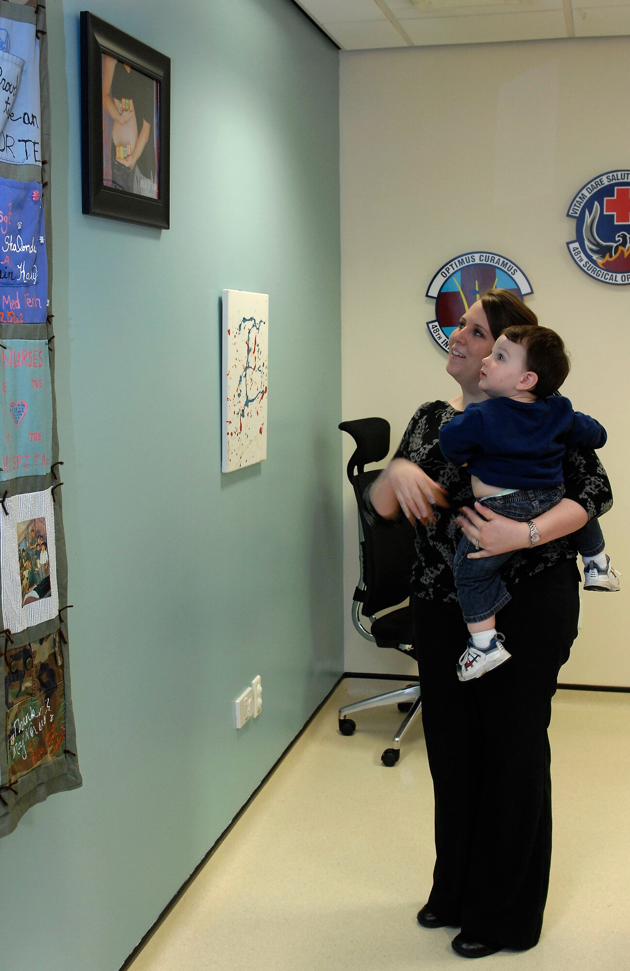 ROYAL AIR FORCE LAKENHEATH, England -- Jenna Jackson and her 16-month-old son, Cameron, look at a donated quilt April 19, 2012.  Families gathered at the obstetrics clinic at the 48th Medical Group hospital as part of grand opening event for a designated private breast feeding area.  (U.S. Air Force photo by Tech. Sgt. Lee A. Osberry Jr.)