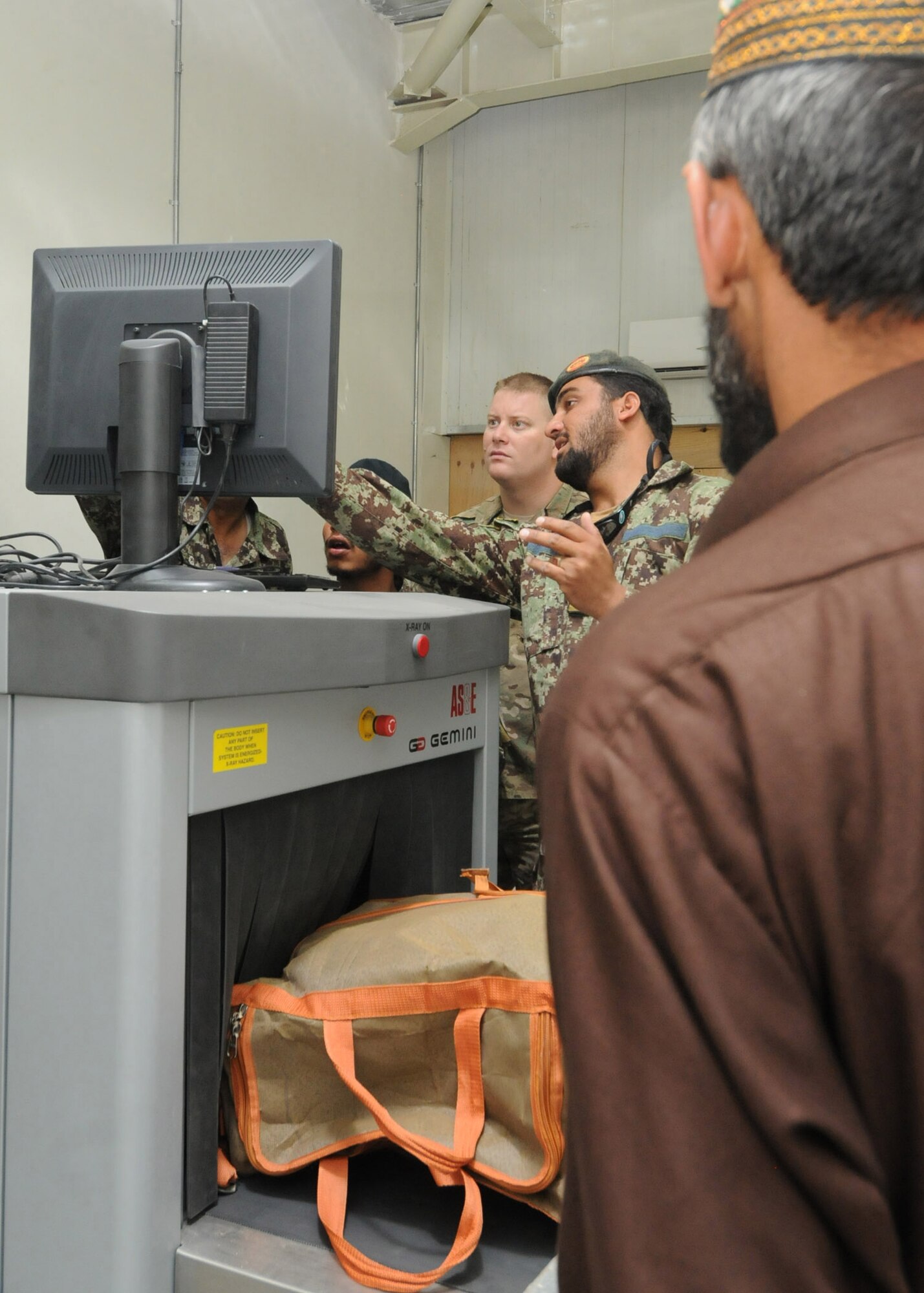 A passenger waits for his baggage to be processed through the Afghan air force passenger terminal by aerial port personnel prior to a flight leaving Kandahar Air Wing, Afghanistan, April 18, 2012.  Advisers from the 738th Air Expeditionary Advisory Group air transportation section are currently training the AAF to manage all cargo and passengers that flow through the KAW AAF passenger terminal. (U.S. Air Force photo by Staff Sgt. Nadine Y. Barclay)