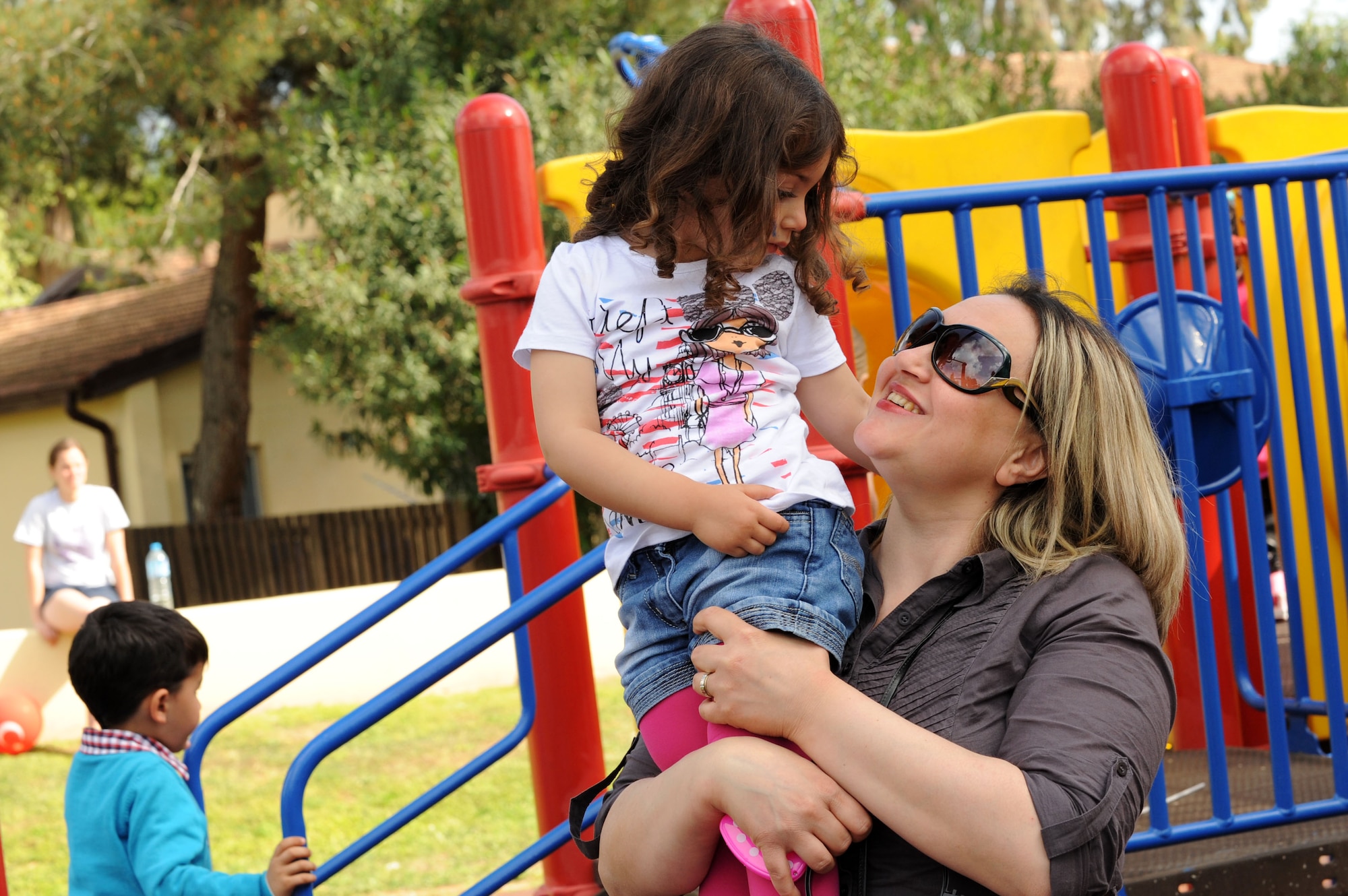 A mother holds her daughter during a Children's Day festival April 22, 2012, at Incirlik Air Base, Turkey. The event was hosted by the Turkish air force 10th Tanker Base Command and was open to all Turkish and American members of Team Incirlik. The event offered an opportunity for camaraderie and building partnership between Turkish and American service members and civilians. Children's Day is a national holiday that honors Turkish children and the future of the country. (U.S. Air Force photo by Senior Airman Jarvie Z. Wallace/Released) 