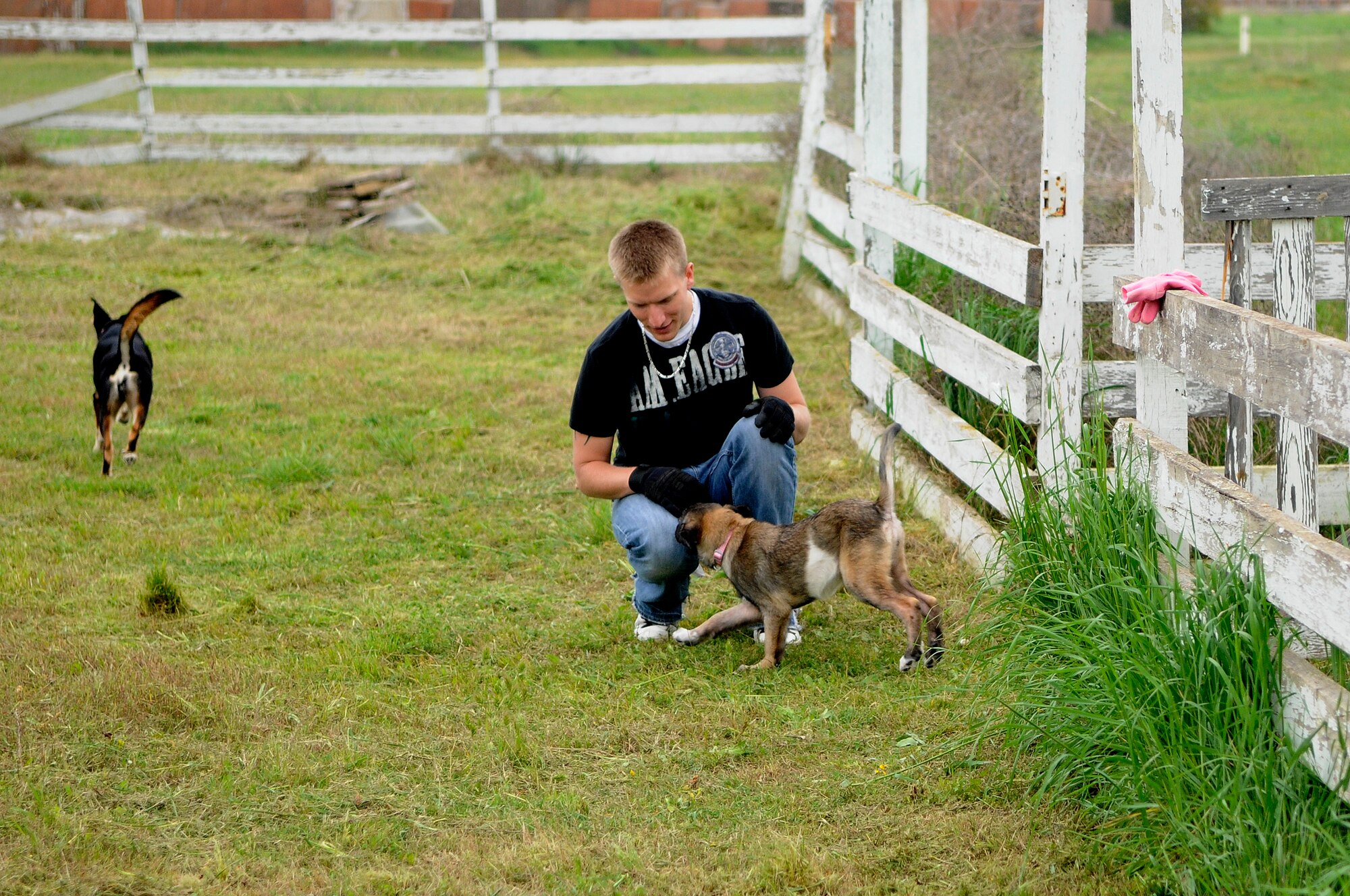 Senior Airman Christopher Tolczyk, 39th Logistics Readiness Squadron, takes a break from cleanup to play with his puppy at the base dog park April 21, 2012, at Incirlik Air Base, Turkey. Twelve volunteers spent five hours gathering trash and debris, mending fences, and mowing to provide a place for the base's furry residents to play. (U.S. Air Force photo by Staff Sgt. Kali L. Gradishar/Released)