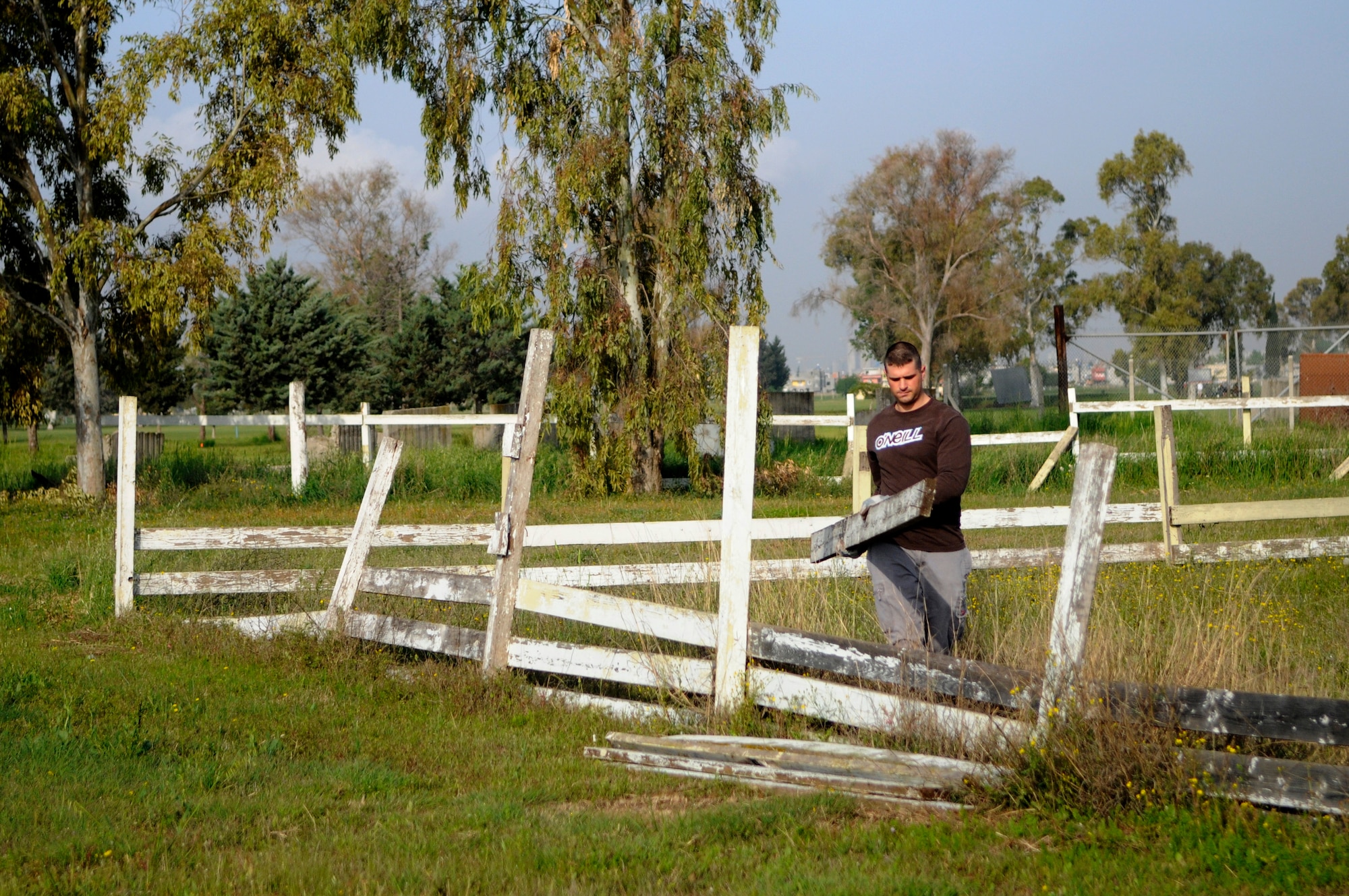 Staff Sgt. Paul Melicia, 39th Security Forces Squadron, removes broken fence boards at the base dog park April 21, 2012, at Incirlik Air Base, Turkey. Twelve volunteers spent five hours gathering trash and debris, mending fences, and mowing to provide a place for the base's furry residents to play. (U.S. Air Force photo by Staff Sgt. Kali L. Gradishar/Released)