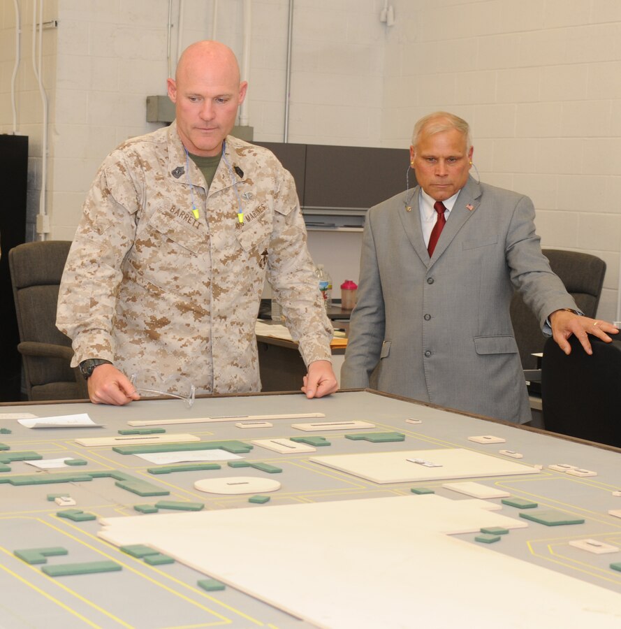 Mike Bogdahn, deputy commander of Marine Depot Maintenance Command, Barstow, shows Sgt. Maj. Micheal P. Barrett a small-scale version of MDMC.