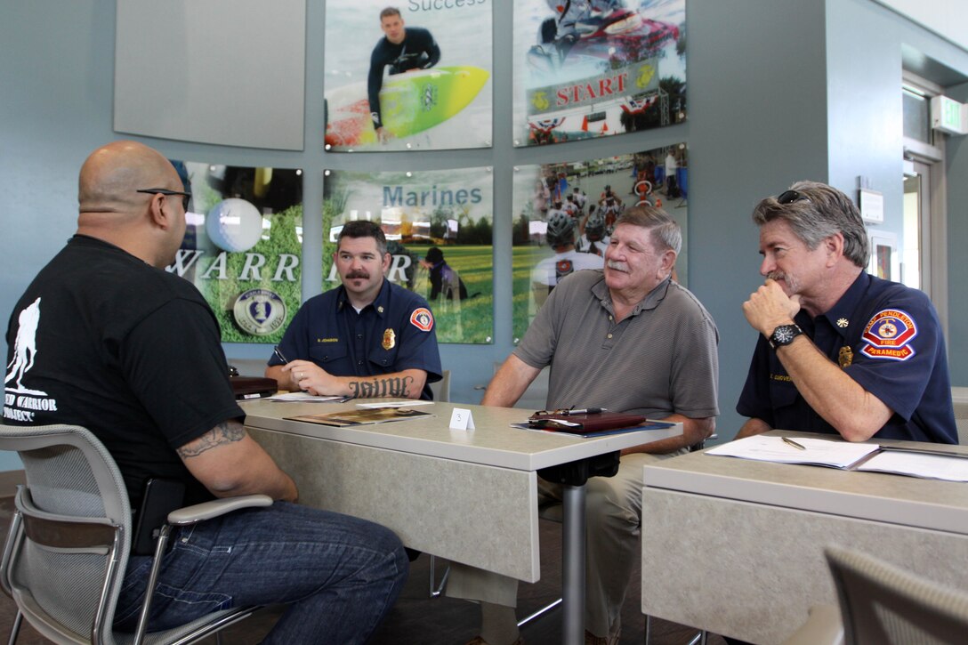 Sgt. Ramond Rivera, a wounded warrior with WWBn.-West, Camp Pendleton speaks with representatives of Camp Pendleton Fire Department during Headquarters Marine Corps Hiring Heroes career seminar, April 24 on Camp Pendleton. The goal of the Marine Corps WWBn. Internship Program is to aid wounded warriors in transition from the military lifestyle to excelling in the civilian workforce.