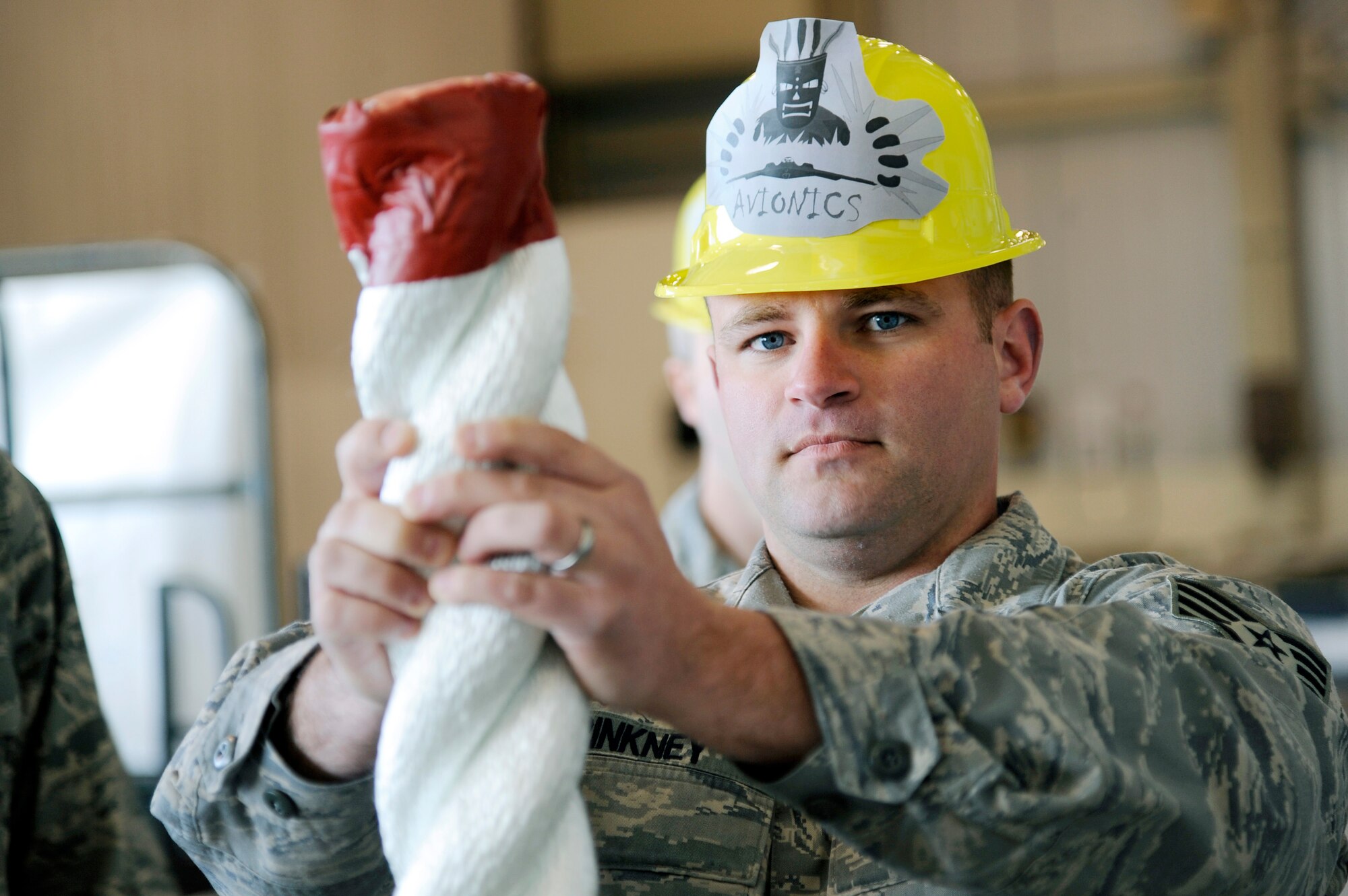 U.S. Air Force Staff Sgt. Adam Pinkney, 354th Maintenance Squadron avionics team member, holds a chock up during the 354th Maintenance Group Olympics chock hold competition April 20, 2012, Eielson Air Force Base, Alaska.  The chock hold competition challenged Airmen to endure holding a chock up longer than opposing teams. A chock is a wedge placed against a wheel to prevent a vehicle from movement. (U.S. Air Force photo/Staff Sgt. Jim Araos)